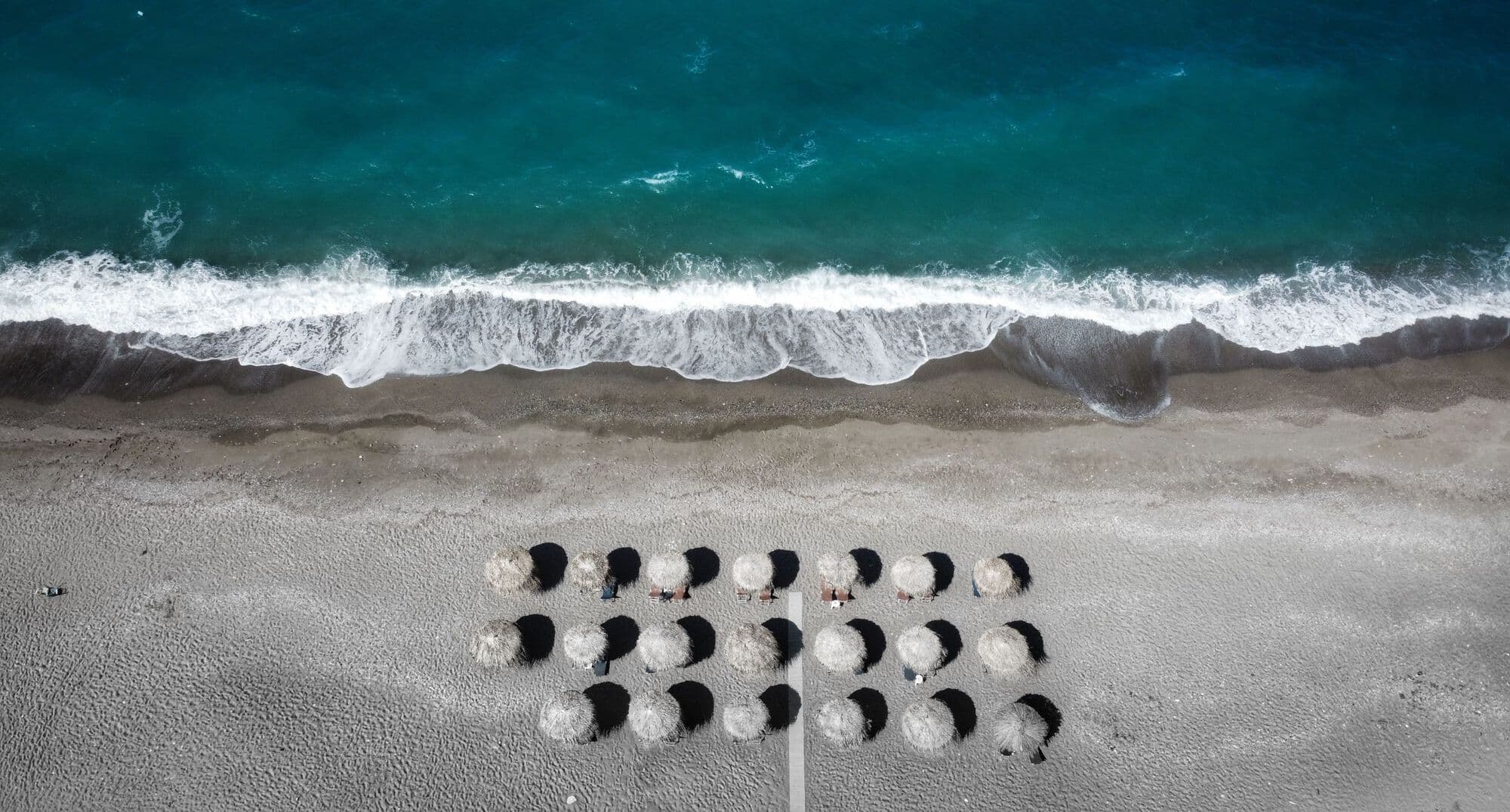 A cluster of beach umbrellas in the middle of an empty beach